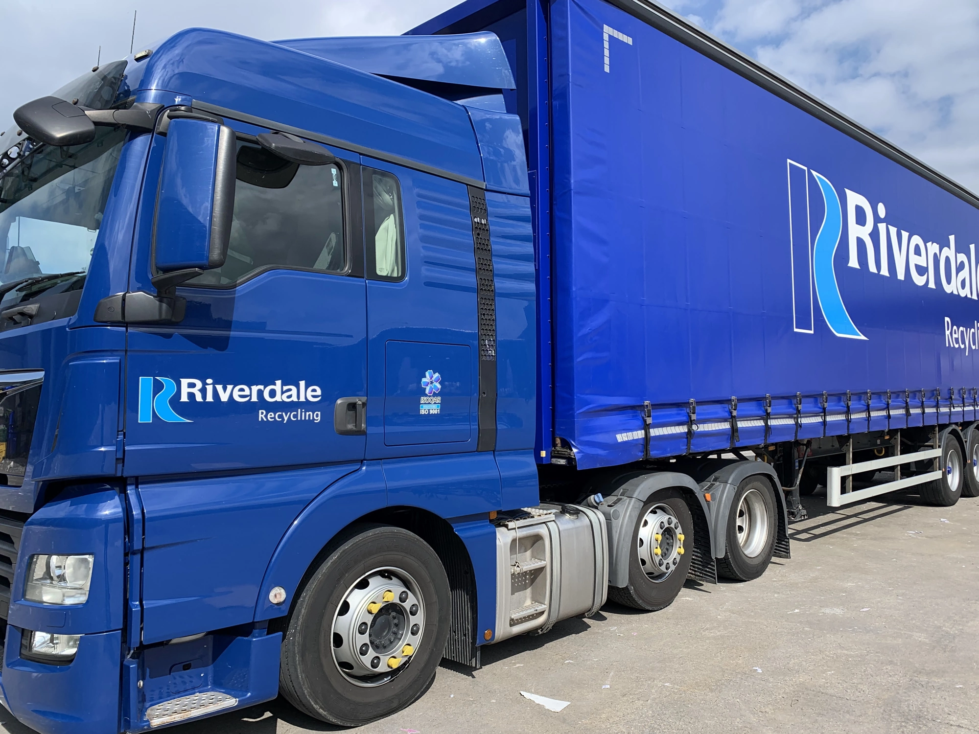 A blue Riverdale Recycling branded truck.