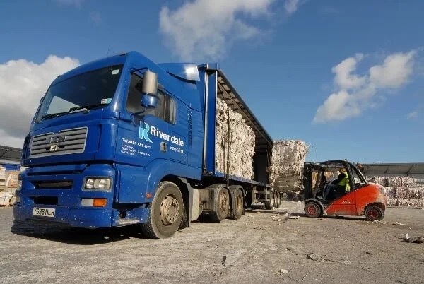 Forklift driver moving shredded paper into a Riverdale branded van.