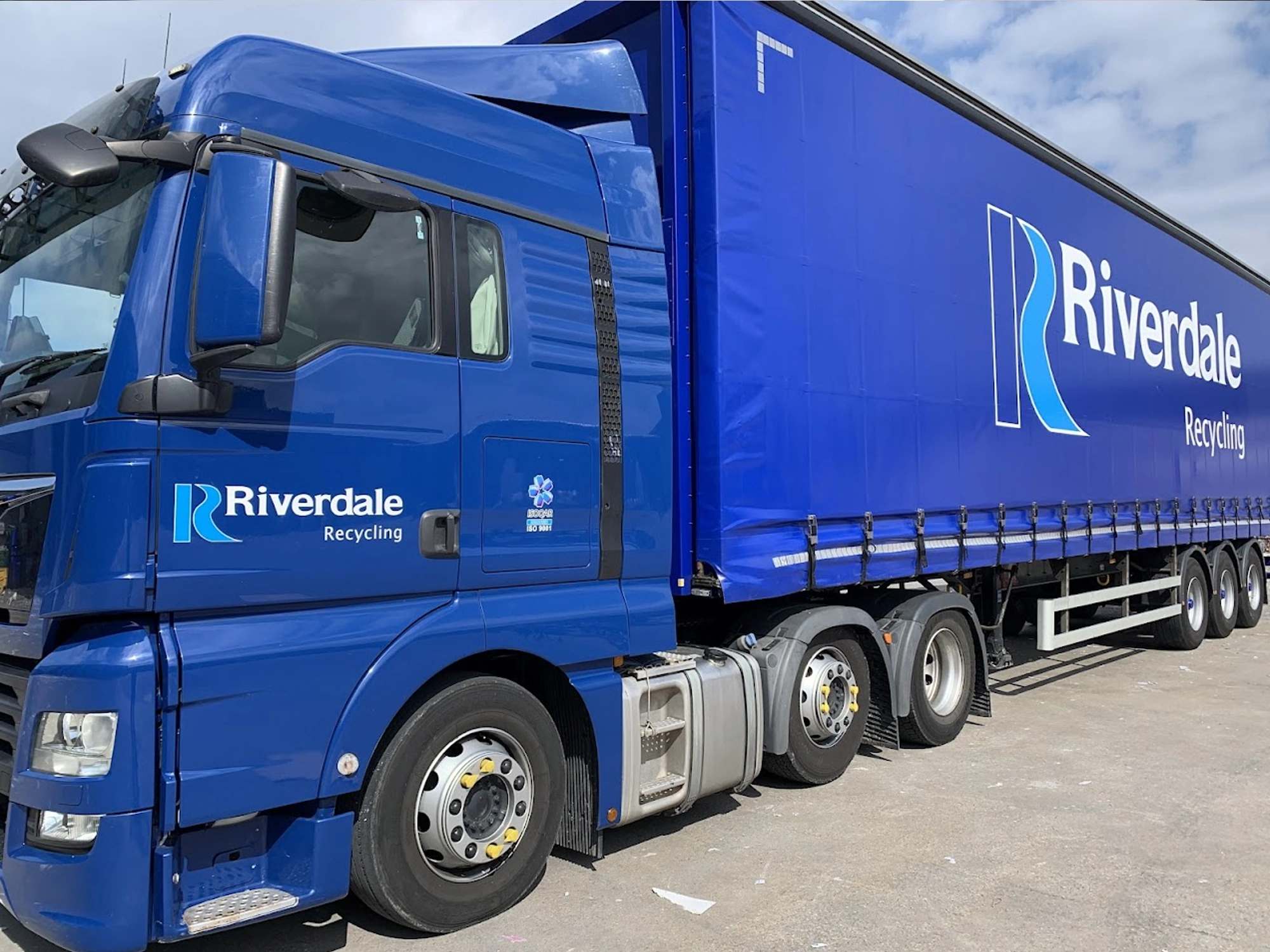 Blue curtain side lorry with Riverdale Recycling logo on side.