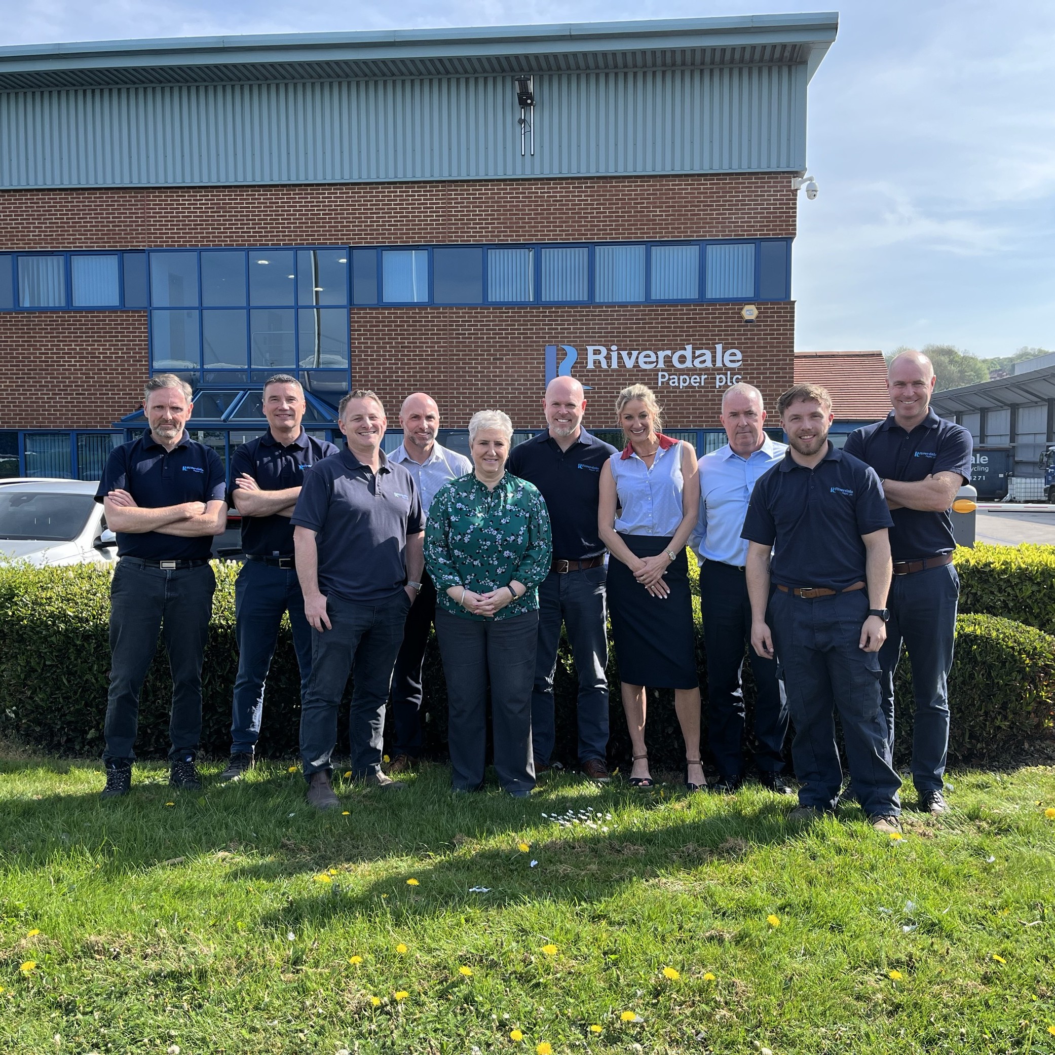 A photograph of the Riverdale Recycling team in front of the building