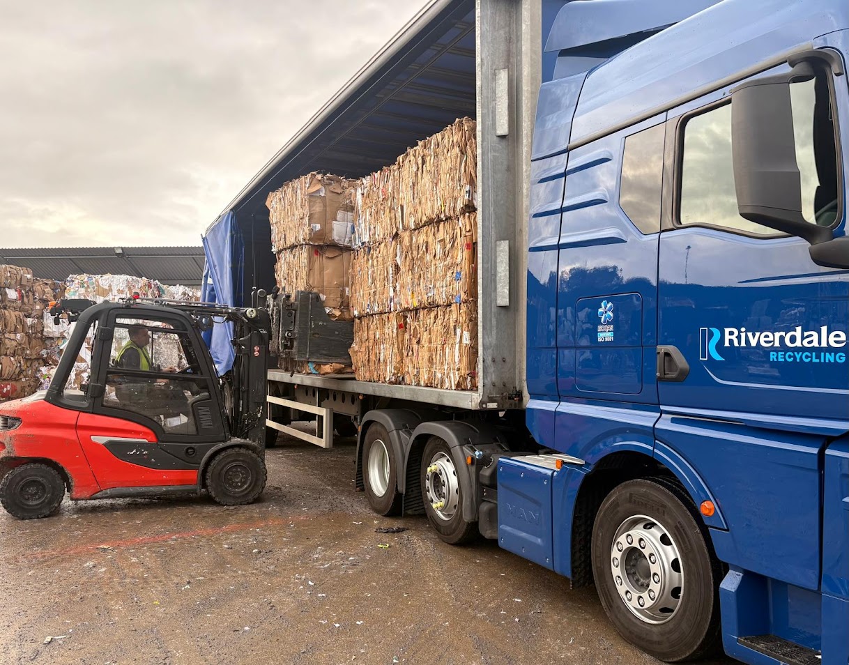 Forklift driver moving shredded paper into a Riverdale branded van.
