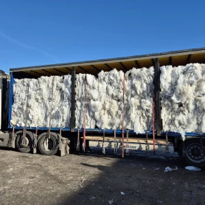 A blue Riverdale Recycling collection truck loaded with baled and sorted polythene packaging.