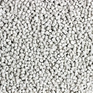 An overhead shot of light grey industrial plastic granules packed tightly together, forming a pebble-like pattern that fills the entire frame.