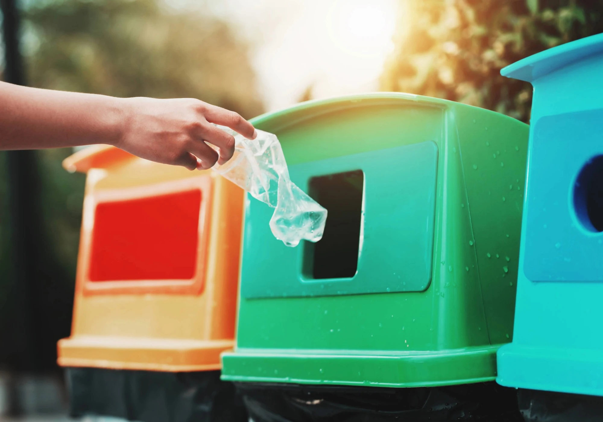 A young student putting a plastic bottle into a campus recycling bin.